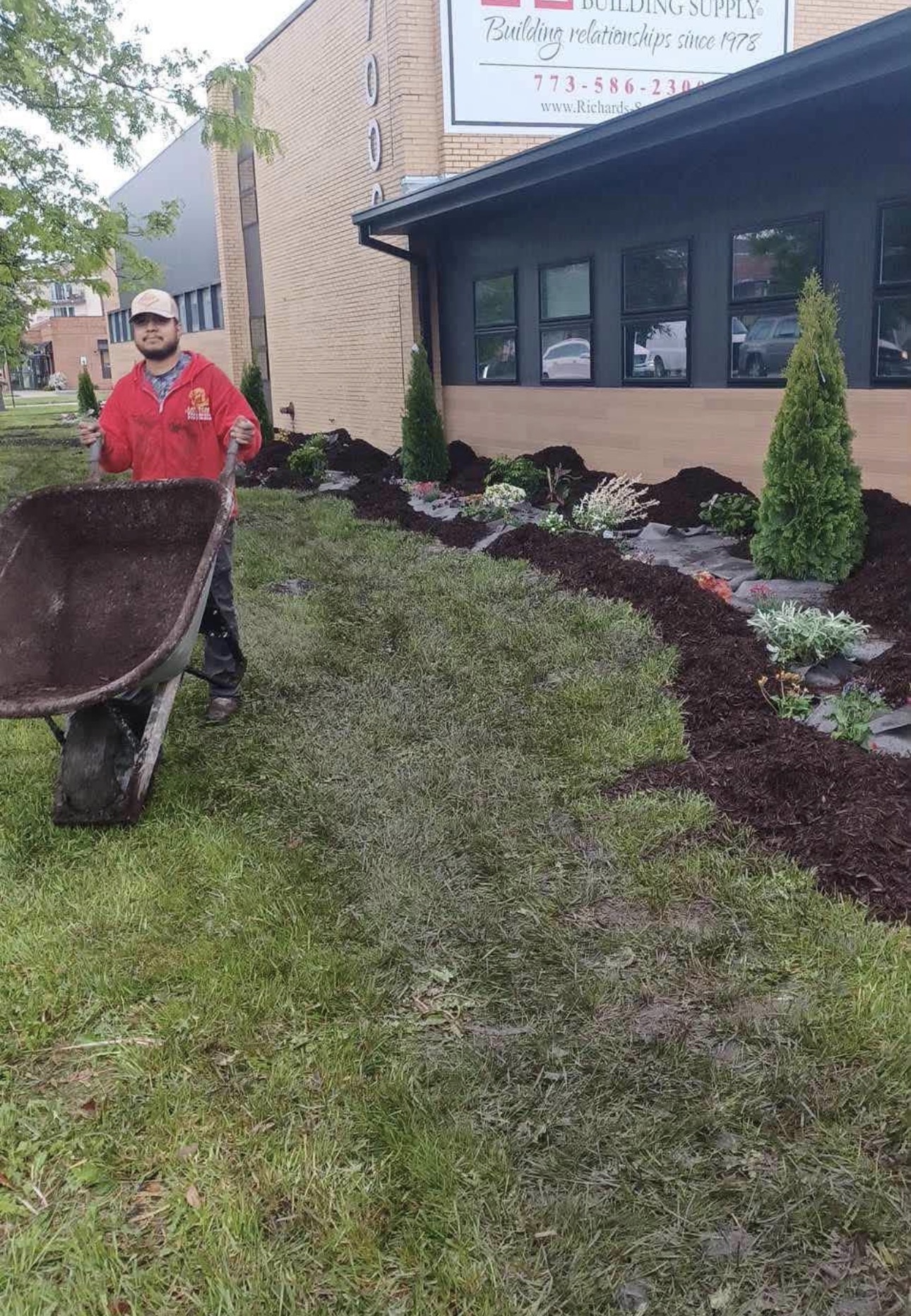 R.G Lawncare crew member installing fresh mulch beds on a commercial property