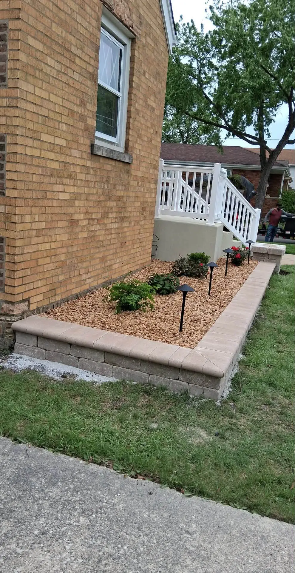 Raised block planter bed with gold gravel, plantings and path lighting
