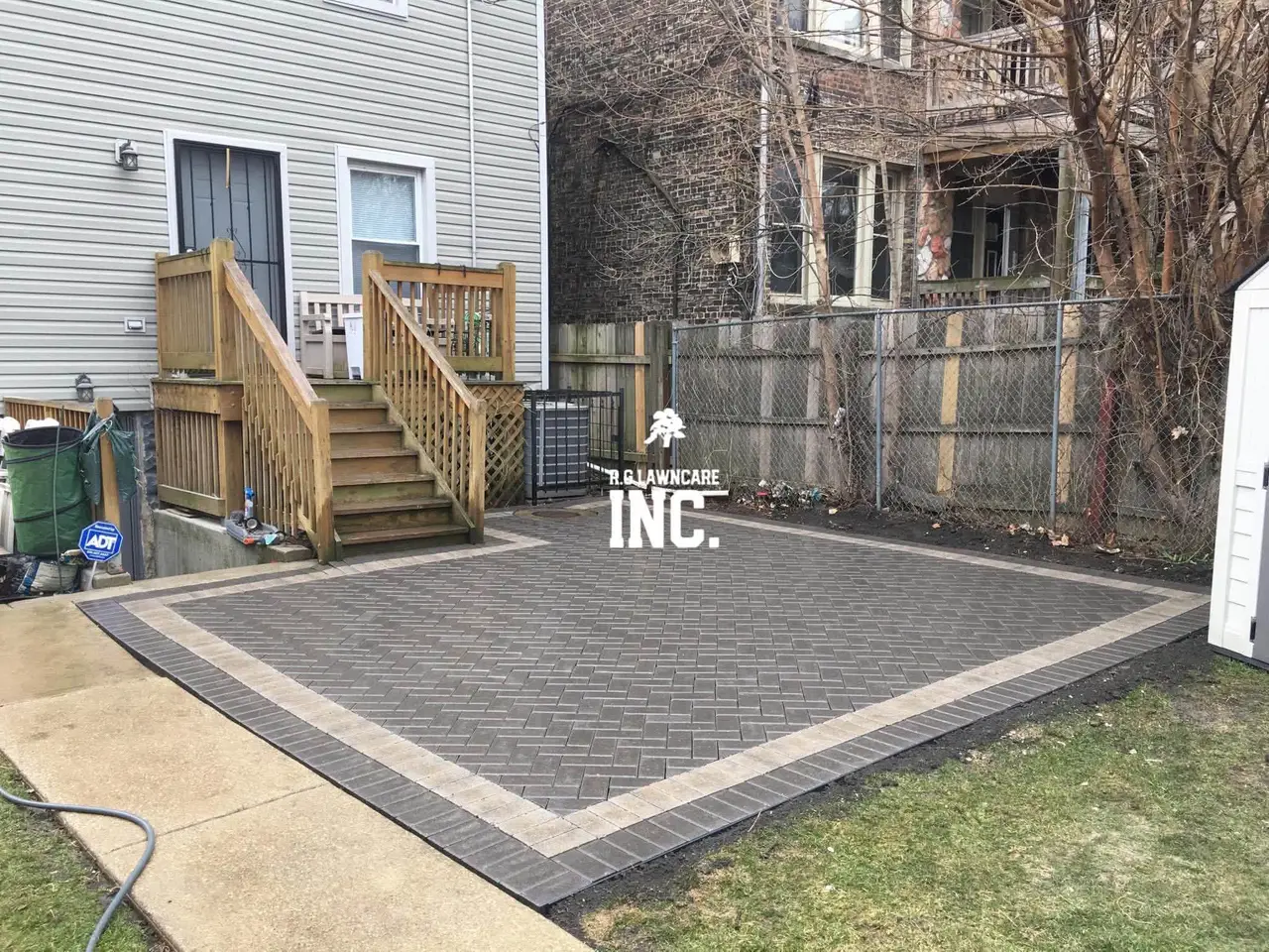 Newly installed herringbone paver patio with contrasting border behind a Chicago home